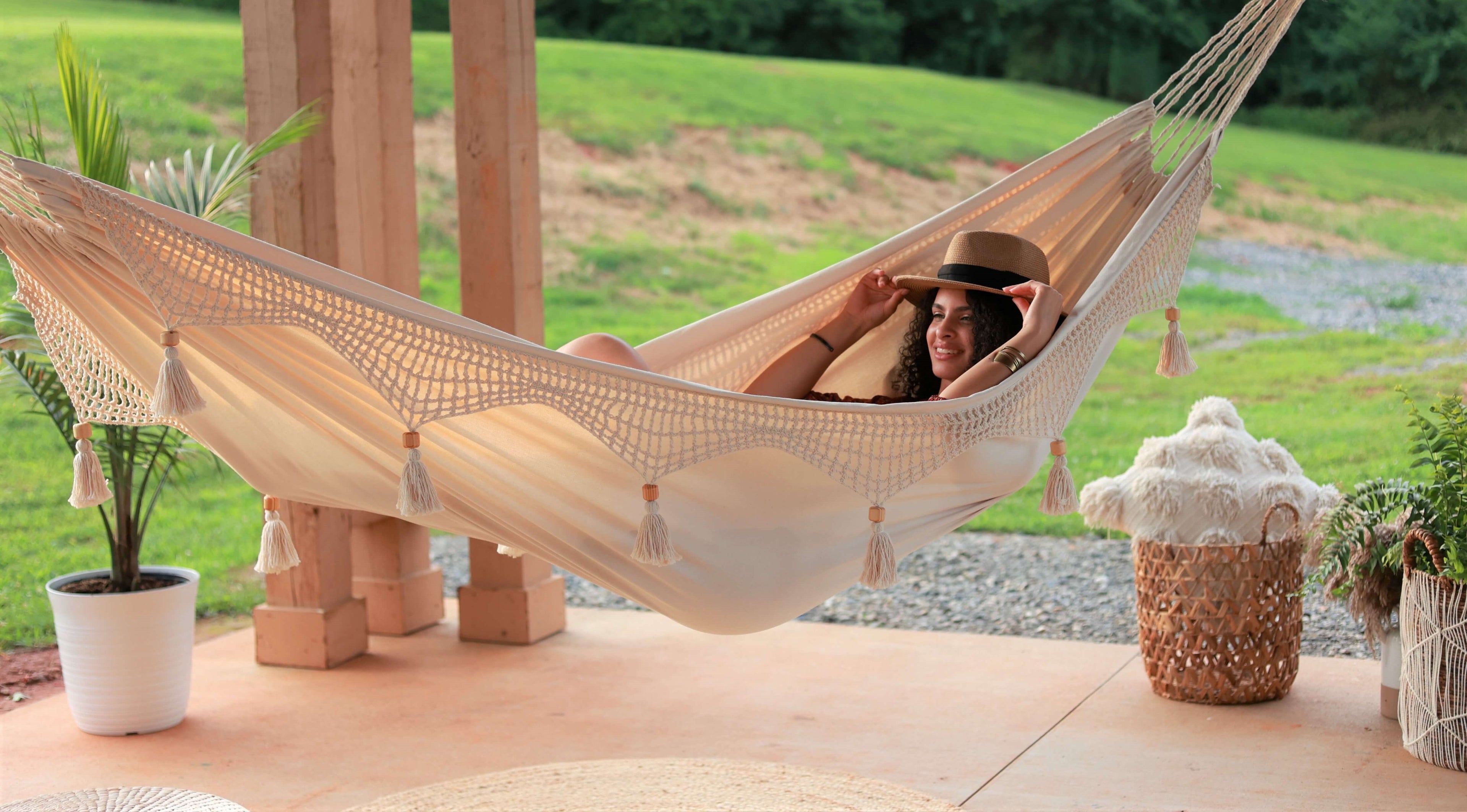 woman relaxing on a boho crochet hammock outdoors