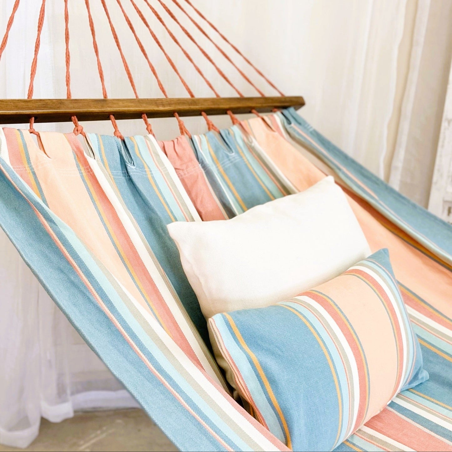 pink and light blue hammock with a white pillow