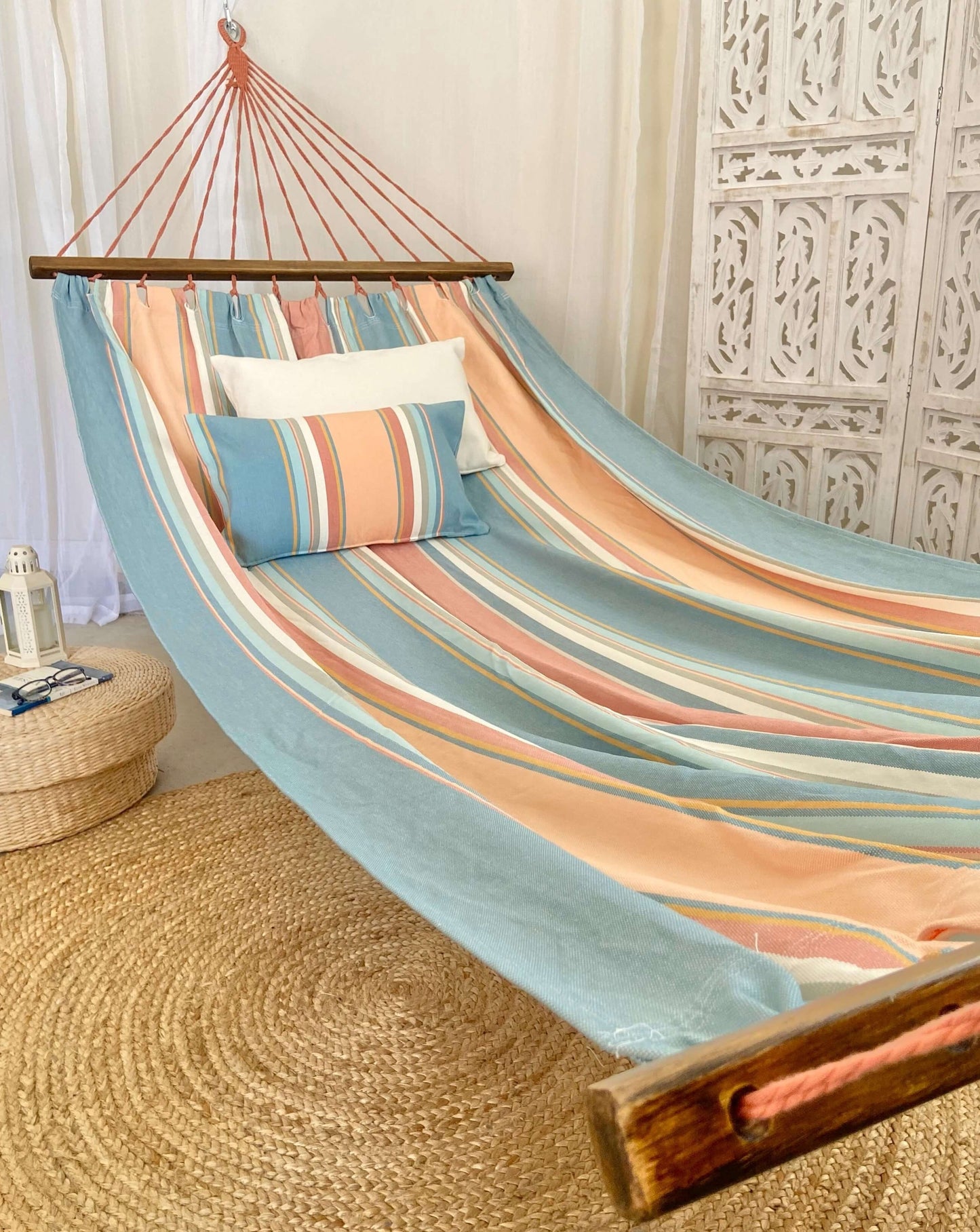 pink and light blue hammock with spreader bars indoors