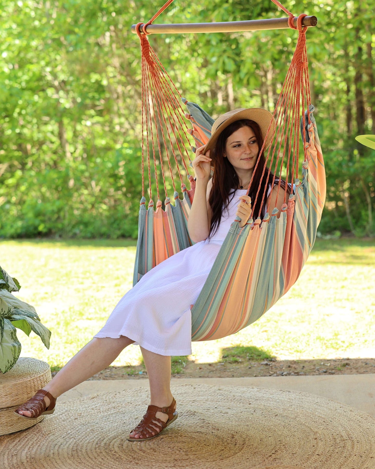 woman sitting on a pink porch swing chair outdoors