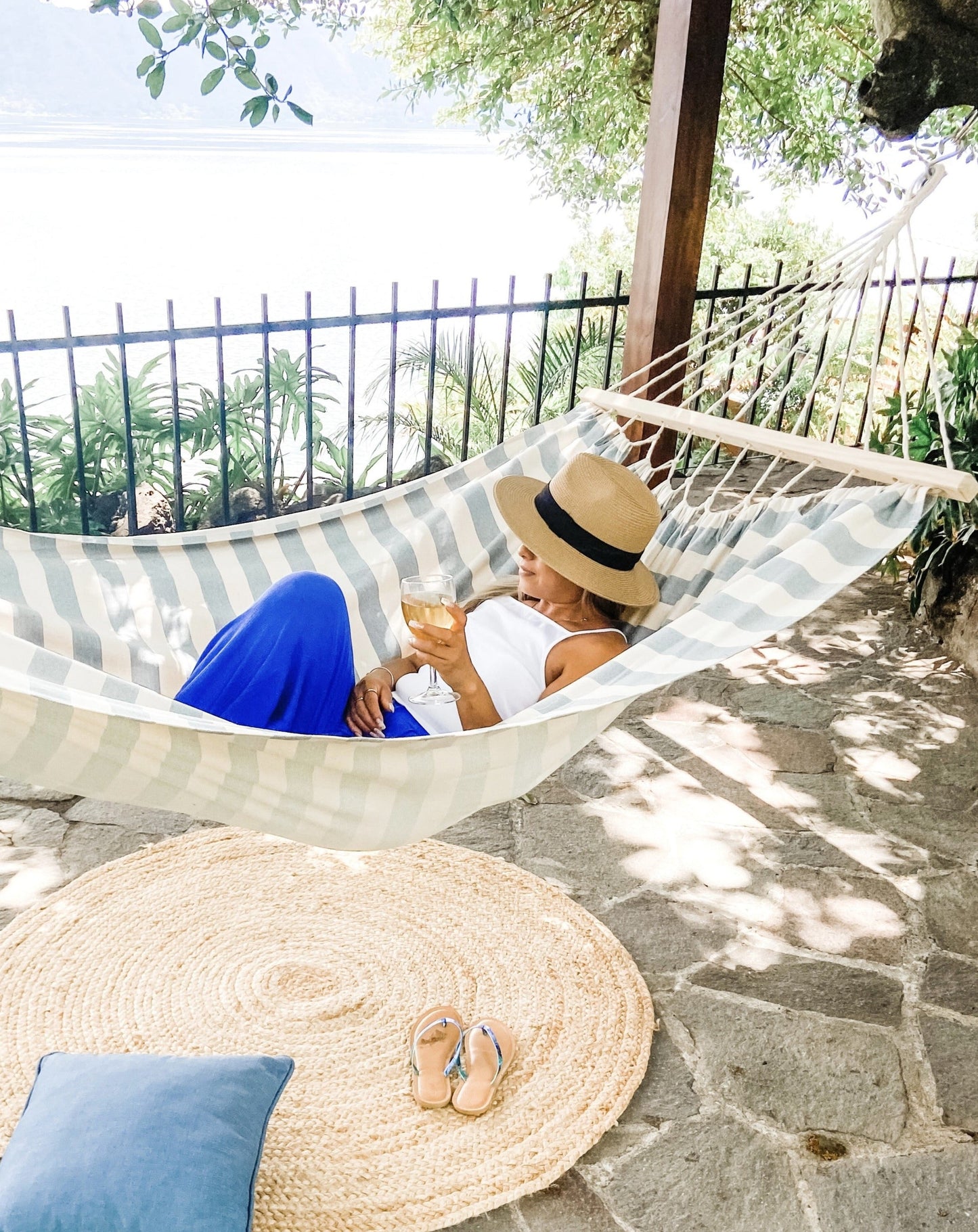 woman resting on a white and blue hammock