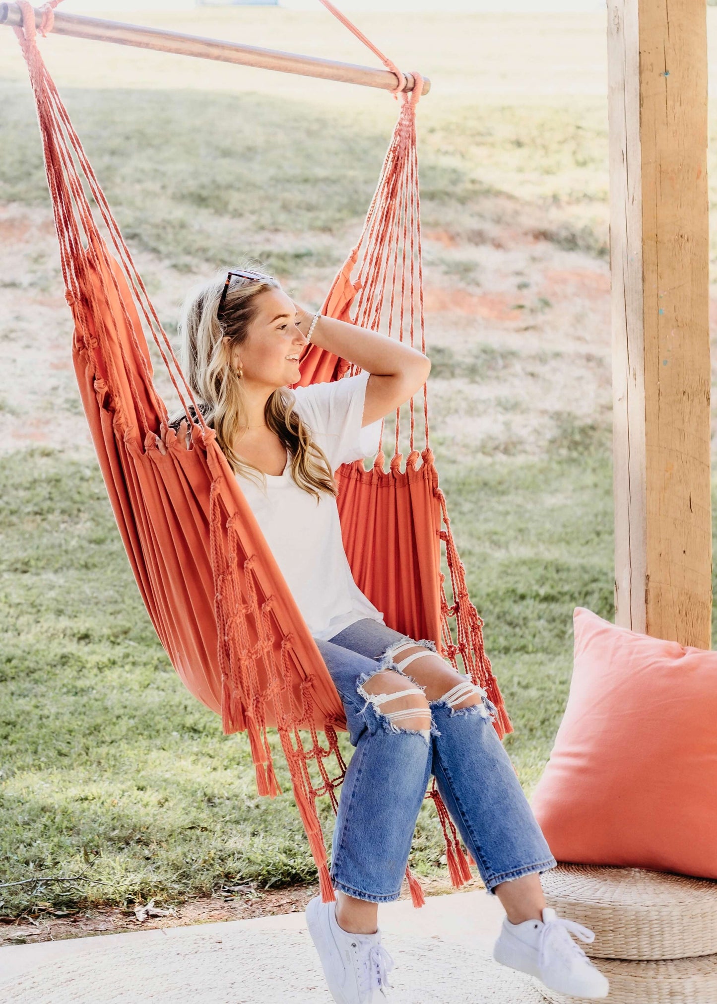 woman sitting on a pink hanging chair hammock