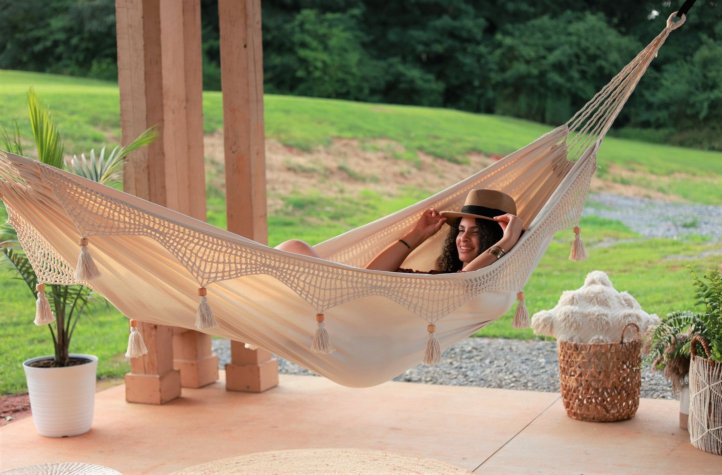 woman on a boho hammock on a porch outdoors