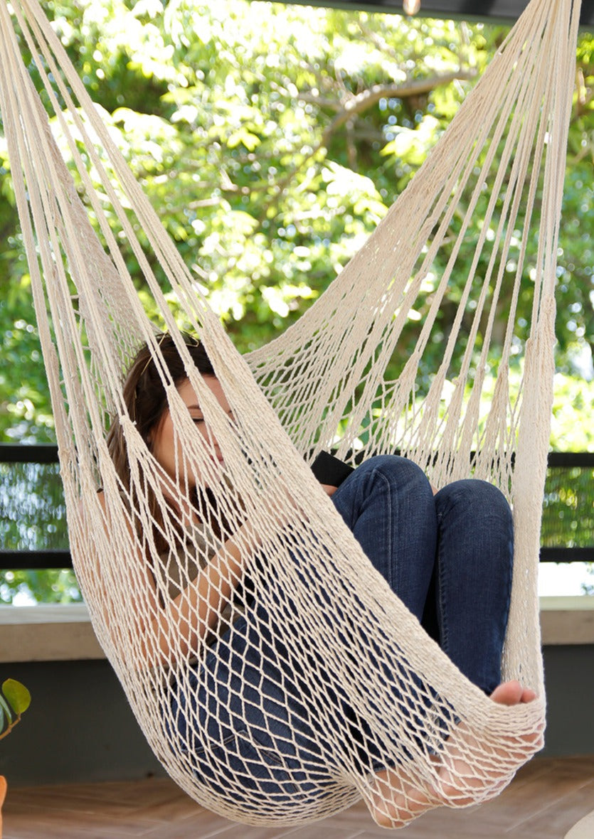 woman sitting on woven hammock chair