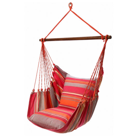 A hanging hammock swing chair with a striped fabric cushion in shades of red, orange, pink, and beige, suspended from a wooden bar with red ropes against a white background.