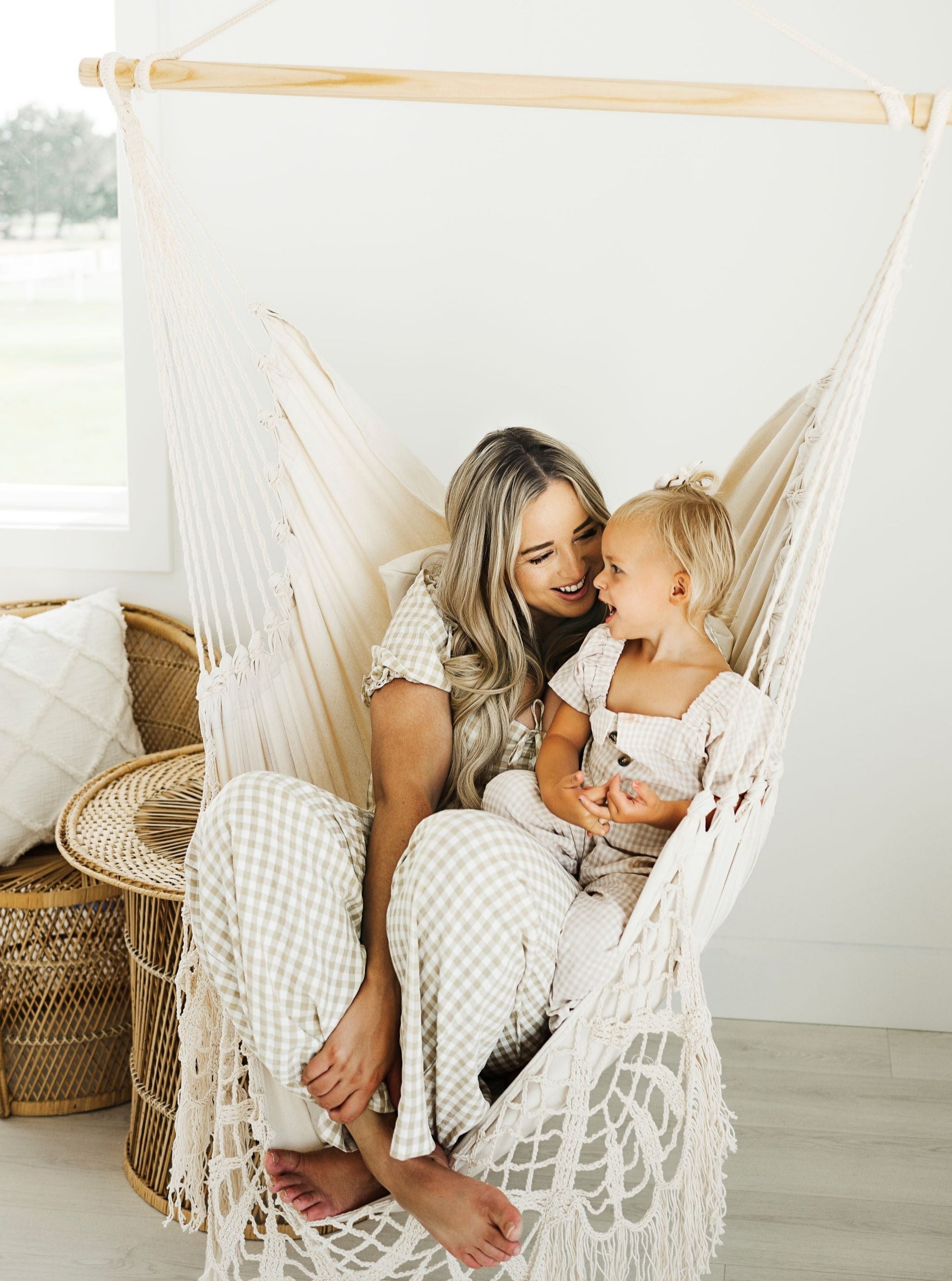 woman and kid sitting on a  white crochet hammock chair swing 