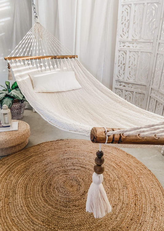 white hammock with spreader bars indoors