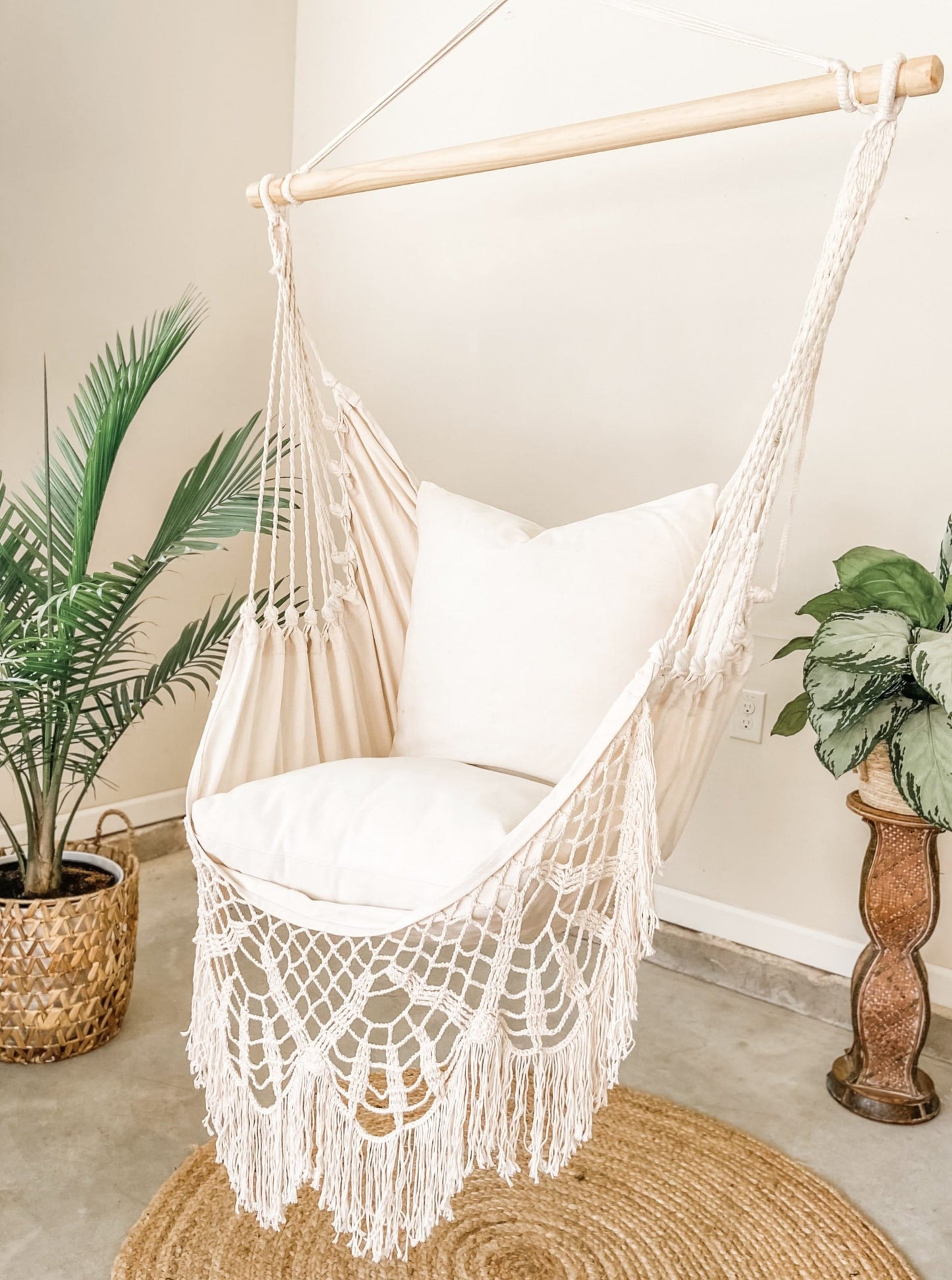 Indoor Crochet Hammock Swing Chair on a jute rug with potted plants. 